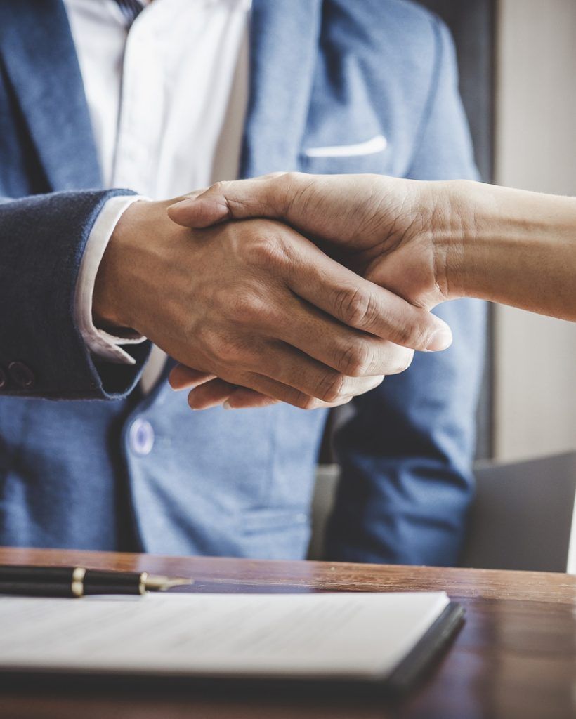Real estate agent and customers shaking hands together celebrating finished contract after about home insurance and investment loan, handshake and successful deal.